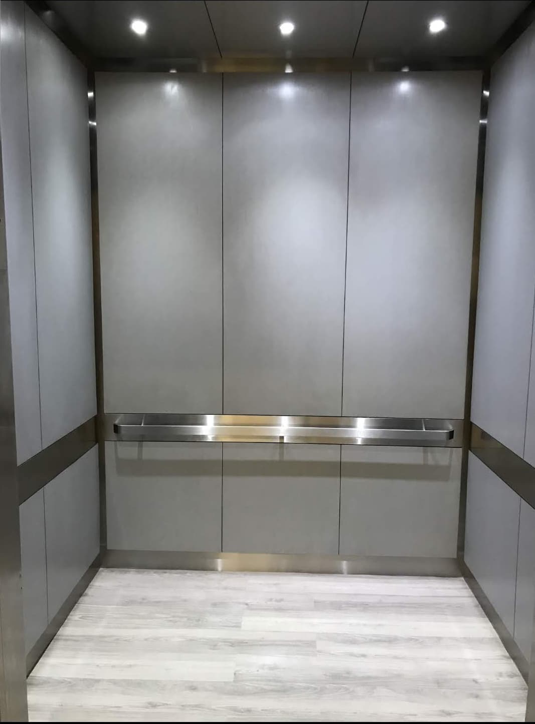 Finished custom elevator cab interior showing coordinated walls, trim, floor and lighting